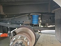 Rear Sumo Spring installed.  Axle is hanging freely.  Other side still has tires on.  Used a 20 ton slim bottle jack from Harbor Freight under the bracket for the axle to lift the tires enough to get...