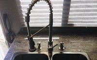 This RV specific kitchen faucet works great, and saves space under the sink since theres no pull-out.  
Also repurposed the other two holes for dish soap and hand soap. Keeps from having soap...