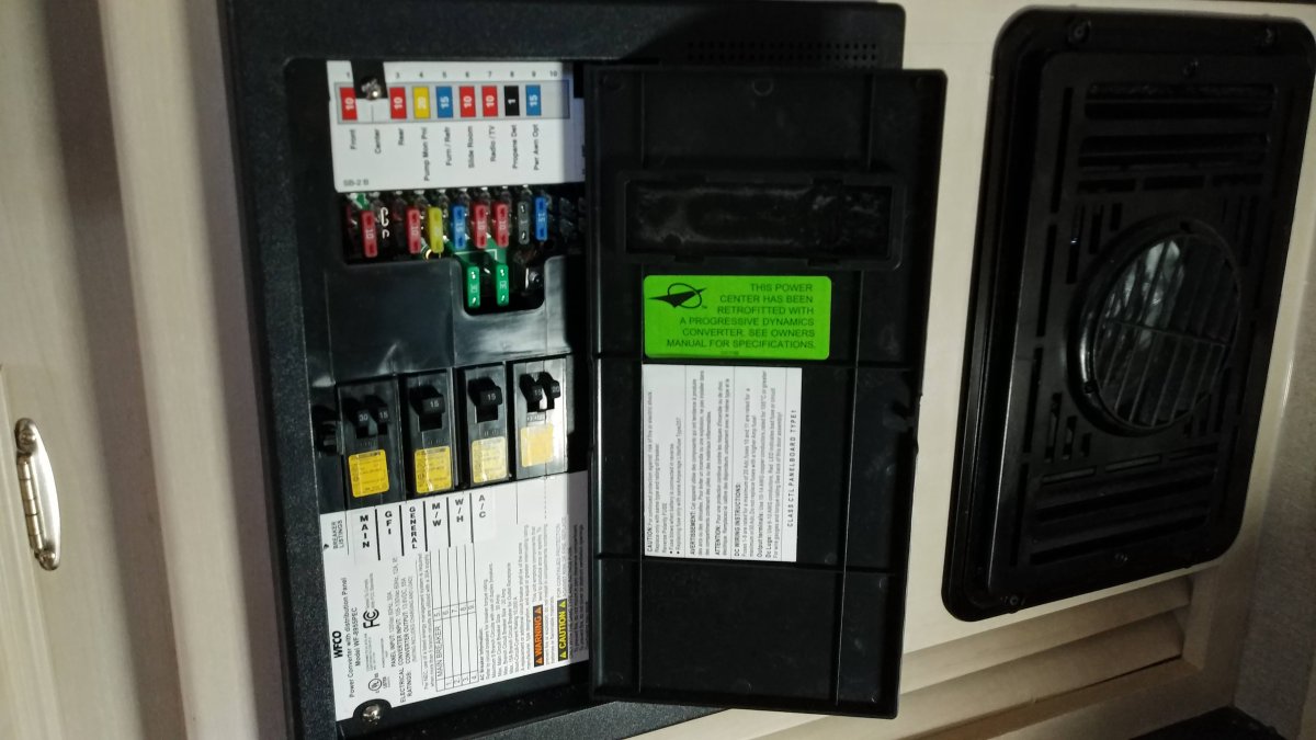 110v circuit breakers and 12v fuse panel is below the refrigerator.  The battery charger is located here also.
